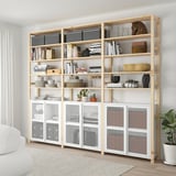 IVAR storage in living area with books, vases, plants, and mesh cabinets.