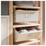 An IVAR storage unit with two drawers. The light-colored drawers are open, revealing items inside.