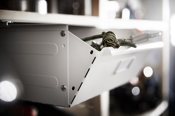 White IVAR drawer, slightly open front, steel frame, rope handle, mounted on wall.