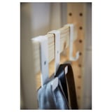 This image an IVAR white metal hook holding a dark object, showcasing a practical and minimalist design.
