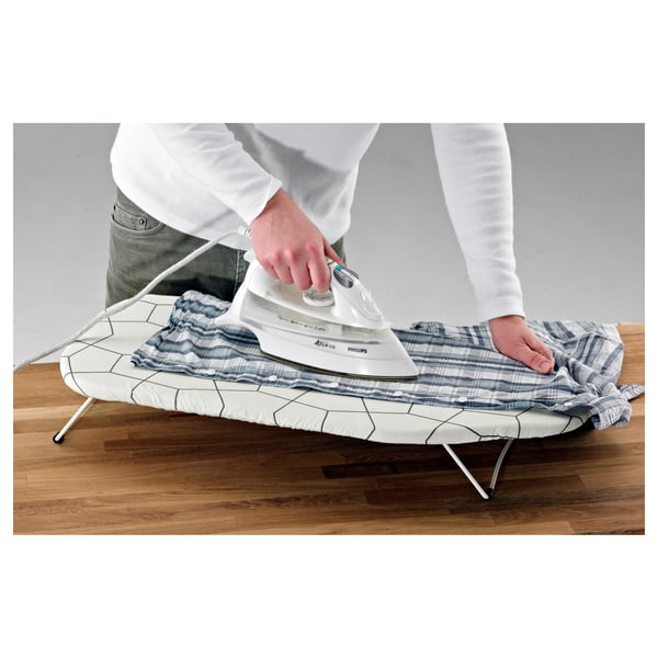Person ironing blue striped shirt on foldable, steel-framed ironing board.