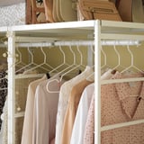 JONAXEL white clothes rack, holding pink and lace clothes, hanging neatly.