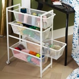 White 3-tier mesh storage cart with wheels, holding colorful yarn skeins and craft items.