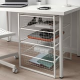 White metal storage with baskets under desk, minimalist decor.