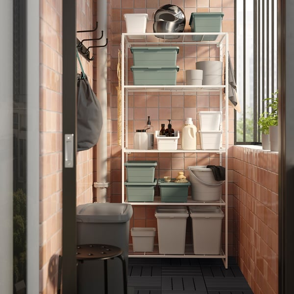 White JOSTEIN shelf with powder-coated steel, red-brown wall, colored containers, hooks for towels/bags, indoor/outdoor.