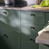 Modern kitchen with green KALLARP drawers, sleek design, rounded handles.