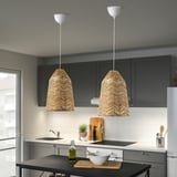Two KAPPELAND rattan pendant lamps illuminate kitchen island, contrasting with gray cabinets and white backsplash. Cozy ambiance.
