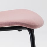 Close-up of a modern pink cushioned chair on a black metal frame, highlighting the comfortable upholstery and sturdy base.