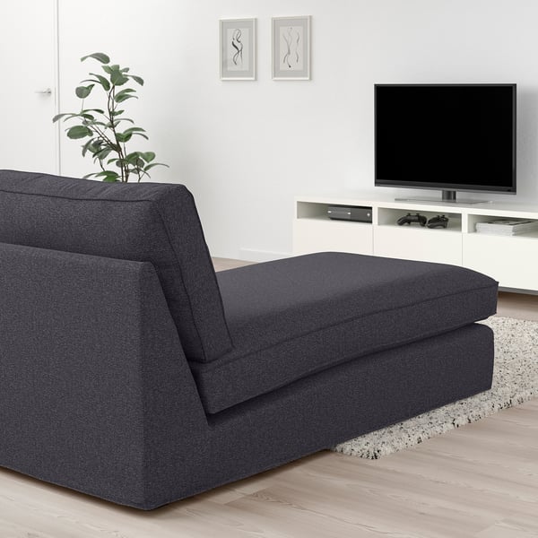 Modern living room with KIVIK gray chaise longue, tv, plant, and frames. Chic and cozy design.