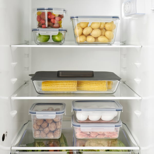 Well-organized fridge shelf, showing vegetables in containers, covered dish, sealed containers.