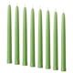 Option: Eight green KLOKHET candles in a row, tall and straight, uniform color and shape, made of stearin.