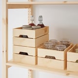 Wooden storage crates stacked on shelves, holding jars and bottles.