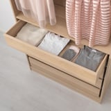 Open pax wardrobe drawer with neatly folded clothes. Integration with KOMPLEMENT boxes for organized storage.
