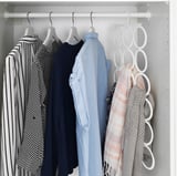 Organized closet with shirts and scarves. KOMPLEMENT hanger displays shawls neatly on right.