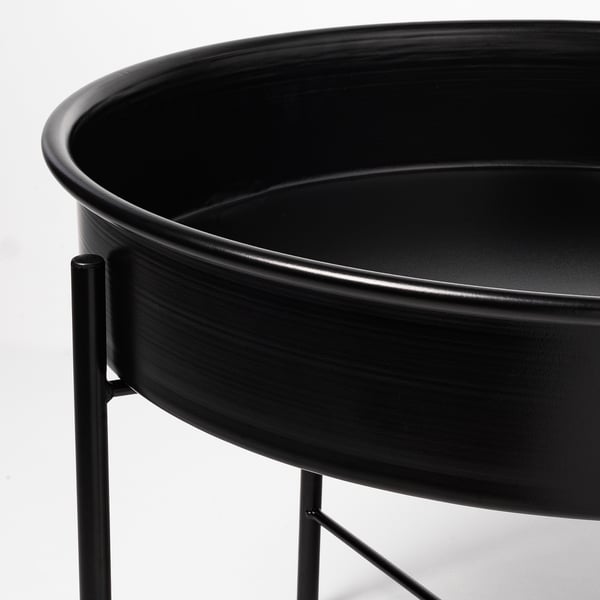 A sleek black metal plant stand with a circular base and supportive legs.