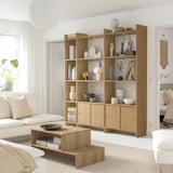 Modern living room with LÅDMAKARE shelves, white vases, sofa, coffee table, pillow, and plant.