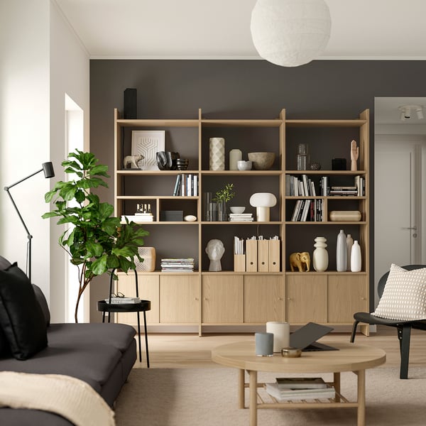 Minimalist living room with bookshelf, sofa, coffee table, and lamp.
