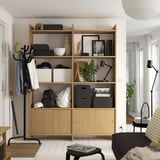 Wooden LÅDMAKARE storage unit with open and closed shelves, displaying various items, set against a white wall.
