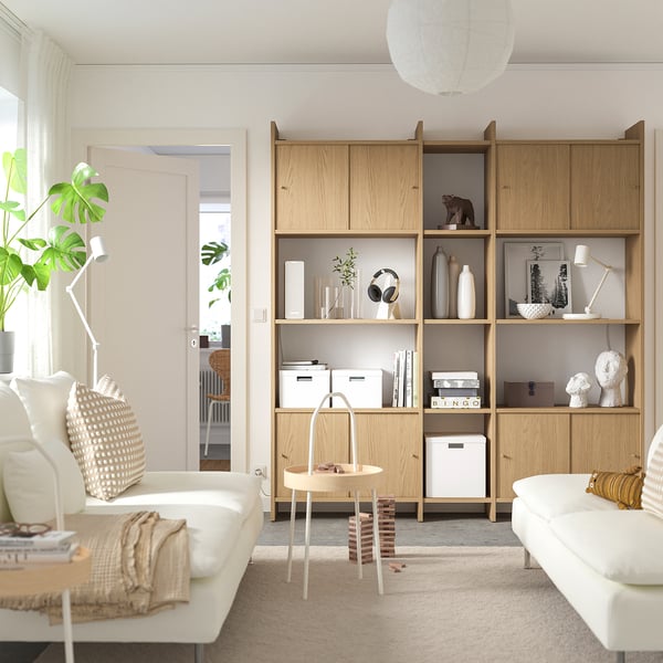 Modern living room LÅDMAKARE light wood storage unit with open and closed shelves, white decor, and cozy white sofas.