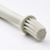 Kitchen brush with dense bristles and sturdy handle.