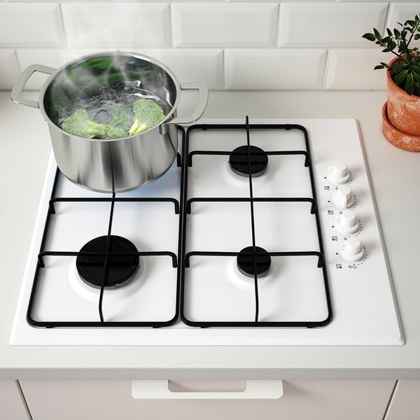 Gas stovetop with boiling broccoli, four burners, two front knobs.