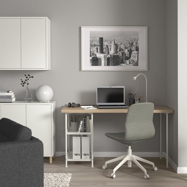 Modern gray home office setup with white LAGKAPTEN desk, green chair, and black & white cityscape artwork, perfect for work or study.