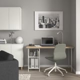 Modern gray home office setup with white LAGKAPTEN desk, green chair, and black & white cityscape artwork, perfect for work or study.