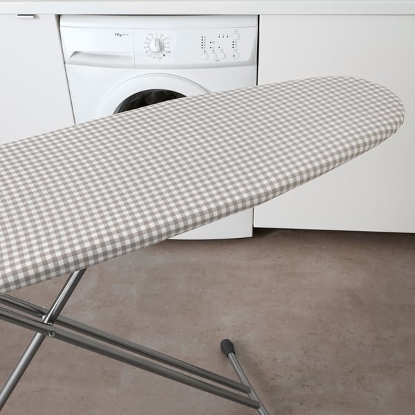 Image shows an ironing board with a new cover featuring a checkered pattern, improving ironing smoothness.