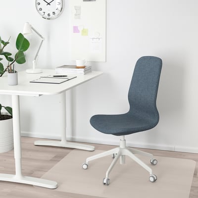 Home office setup: white desk, blue LÅNGFJÄLL chair, white lamp, plant, clock.