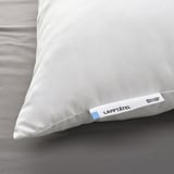 Close-up of a white pillow labeled LAPPTÅTEL by ikea, exhibiting soft, high-quality microfibre fabric, resting on a bed.