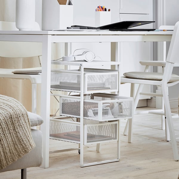Home office with white LENNART storage drawers. Desk with items, chair, light grey flooring.