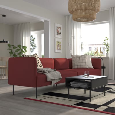Modern living room with red LILLEHEM modular sofa, patterned rug, coffee table, and large window.