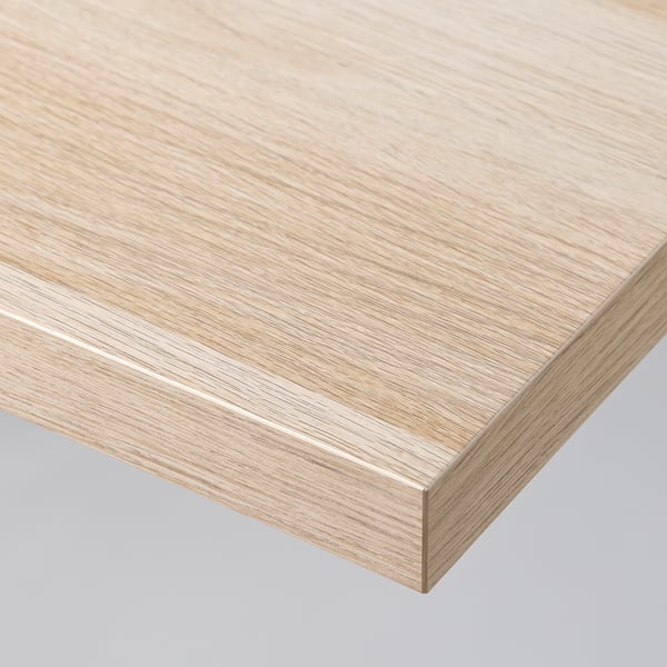 Close-up of a light wood-grained tabletop with a sleek, flat surface and neatly finished edges, showcasing high-quality craftsmanship.
