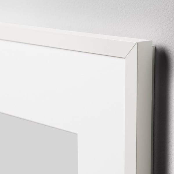 A sleek, white picture frame with a thin, crisp edge, leaning against a wall, showcasing its minimalist design and quality construction.