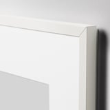 A sleek, white picture frame with a thin, crisp edge, leaning against a wall, showcasing its minimalist design and quality construction.