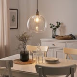 Cozy dining room with glass pendant, wooden table, and floral decor.