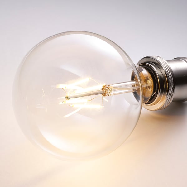 Vintage led bulb glowing warmly, in metallic base.