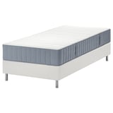 Modern, white bed with blue-gray mattress, raised on legs.