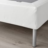 White LYNGÖR bed base with stainless steel legs supports mattress, enhancing comfort and air circulation.