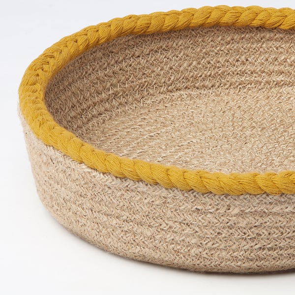 Handwoven jute basket with yellow cotton edge, showcasing natural textures and craftsmanship.