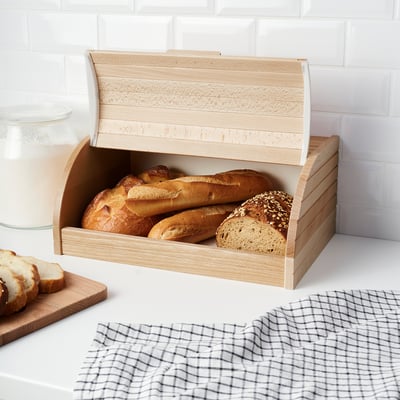 Light wooden bread bin stores various loaves, keeping kitchen neat and organized.