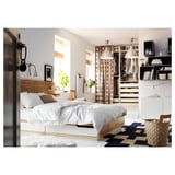 Minimalist bedroom with white MANDAL bedframe, wood headboard, blackout curtains, and blue checker rug.