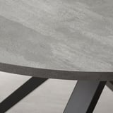 Close-up of a modern round table with smooth edges and a black metal frame, showcasing its sleek, durable design.