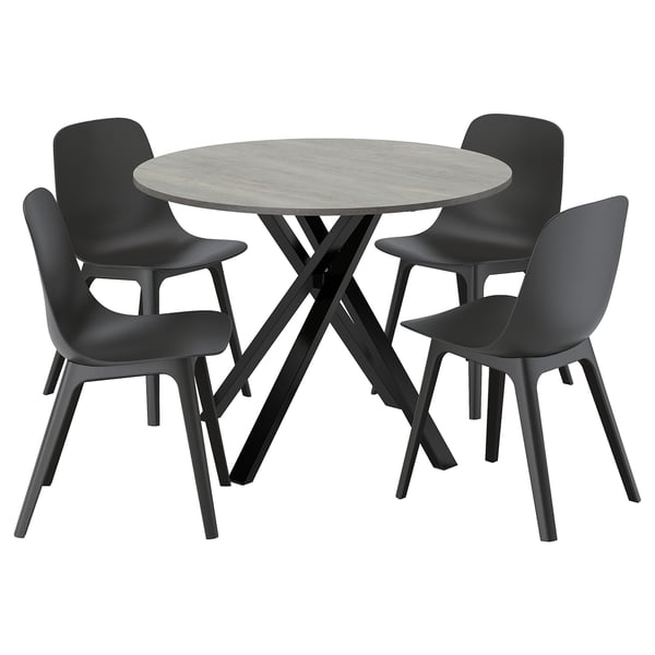 Grey round dining set with 4 black chairs, stone table, comfy design.