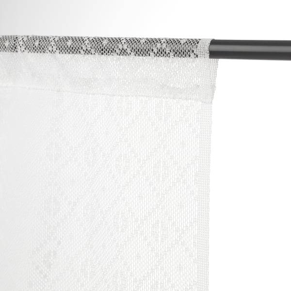 Light white curtains hang from black rod, offering privacy and filtering daylight.