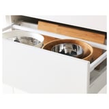 White kitchen drawer fully extended showcasing utensil tray with steel strainer and mixing bowls, highlighting organized access and smooth closure.