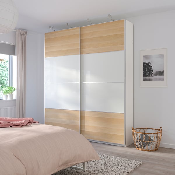 MEHAMN wardrobe with mirrored & wood panels, tall, beside bed.