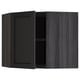 Black stained kitchen cabinet with one open door, dark wood grain.