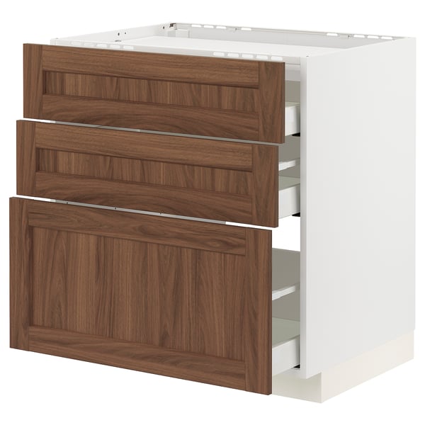 An ikea METOD kitchen cabinet. It three walnut-colored drawers in a white frame, offering a warm, classic look with wood grain texture.