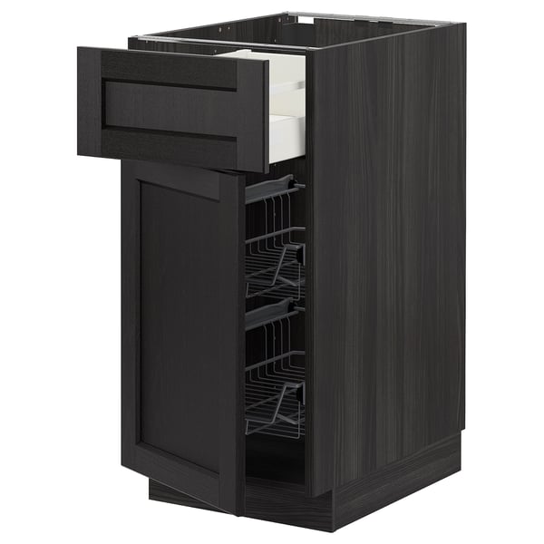 Displays a black stained ash METOD kitchen cabinet with a wooden drawer and wire basket pulled out. It a smooth and traditional design.